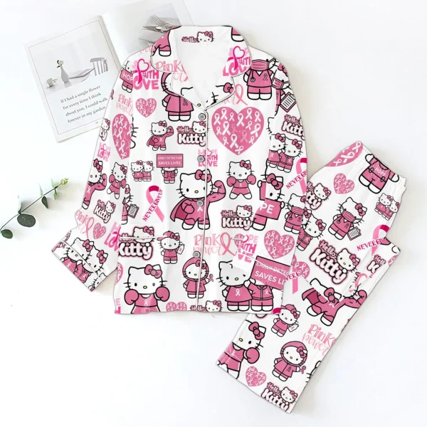 Hello Kitty Pink Power Never Give Up satin pajamas set laid flat on a white surface next to a book and plant.