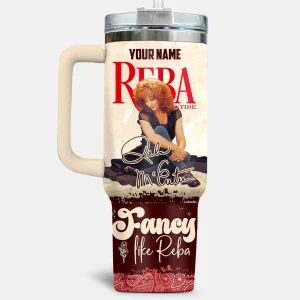 Front of the Reba McEntire tumbler featuring her photo, signature, and the text 'Fancy like Reba' on a red paisley pattern.
